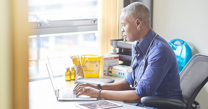 A female doctor sits at her desk