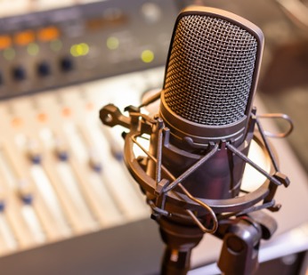 a microphone in front of an audio editing board